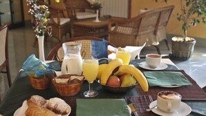 Ein Frühstückstisch mit Früchten, Gebäck und Getränken.