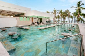 A pool area with a bar, seating, and palm trees.