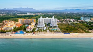 Un complexe hôtelier comprenant plusieurs bâtiments, une plage et un espace piscine.