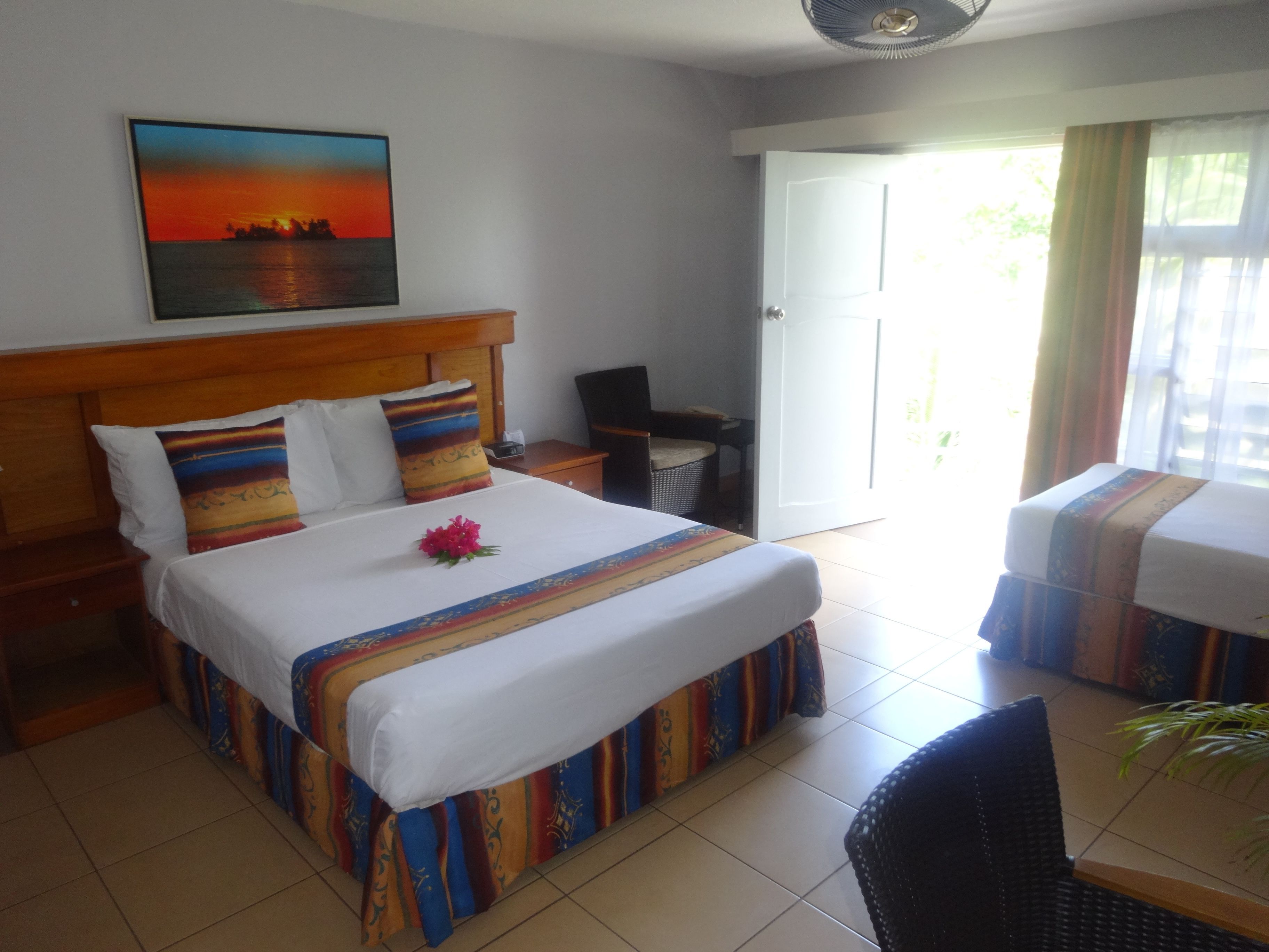 Ein Hotelzimmer mit einem Bett, einem Schreibtisch, einem Stuhl und Blick ins Freie.
