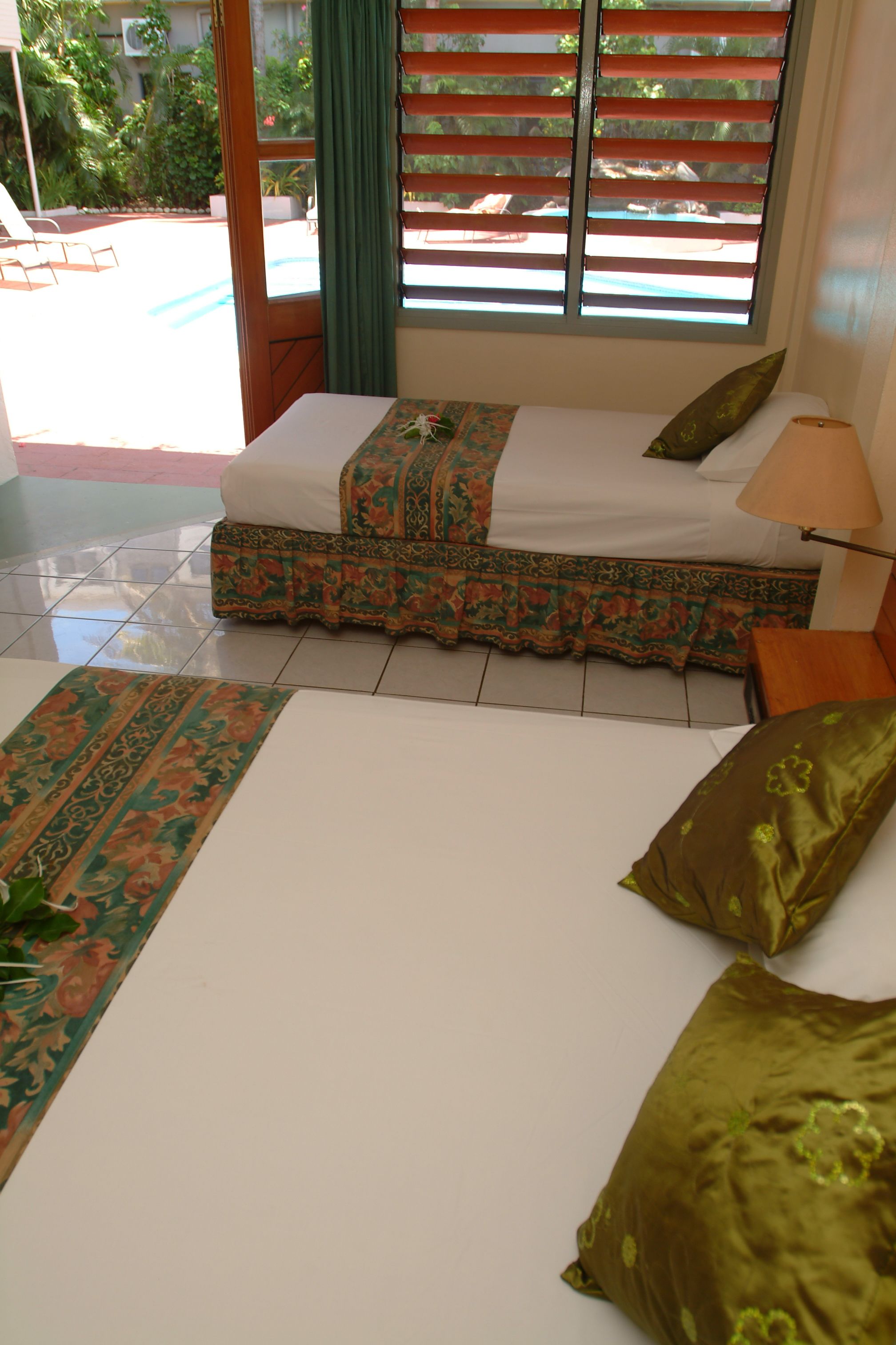 Una habitación con una cama, un sofá y una ventana con persianas.