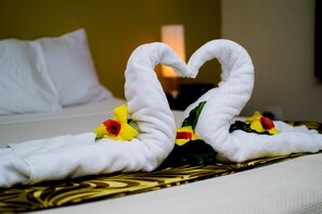 A bed with white linens and a decorative towel arrangement in the shape of a heart. - Hexagon International Hotel (Nadi)