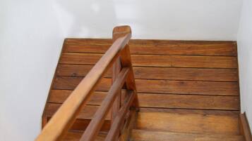 A wooden staircase with a handrail leading up to a landing.