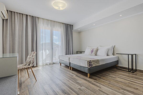 Une chambre d’hôtel moderne avec un grand lit, un bureau et une chaise.