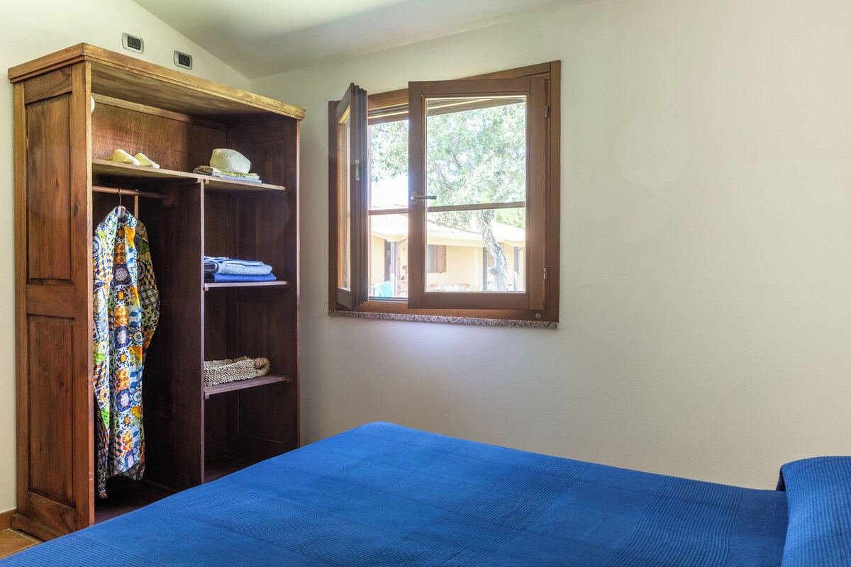 Une chambre à coucher avec un lit, une armoire et une fenêtre.