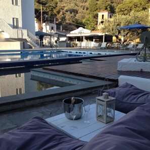 Una piscina al aire libre de temporada, sombrillas
