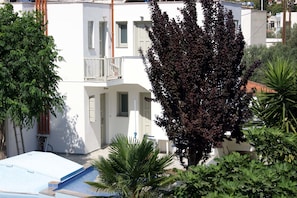 A white building with balconies and a swimming pool. - Cascade Holiday Resort (Poros)