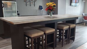 A modern kitchen with a large island, bar stools, and a vase of flowers. - Microtel Inn & Suites by Wyndham Hoover/Birmingham (Birmingham)