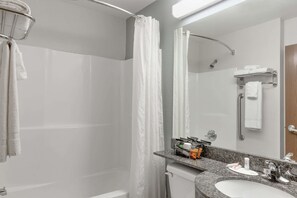 Un baño moderno con ducha, lavamanos y espejo.