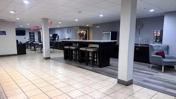 A clean, modern lobby with a reception desk, seating area, and a vending machine.