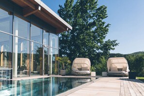 Een binnenzwembad, een buitenzwembad, parasols voor strand/zwembad