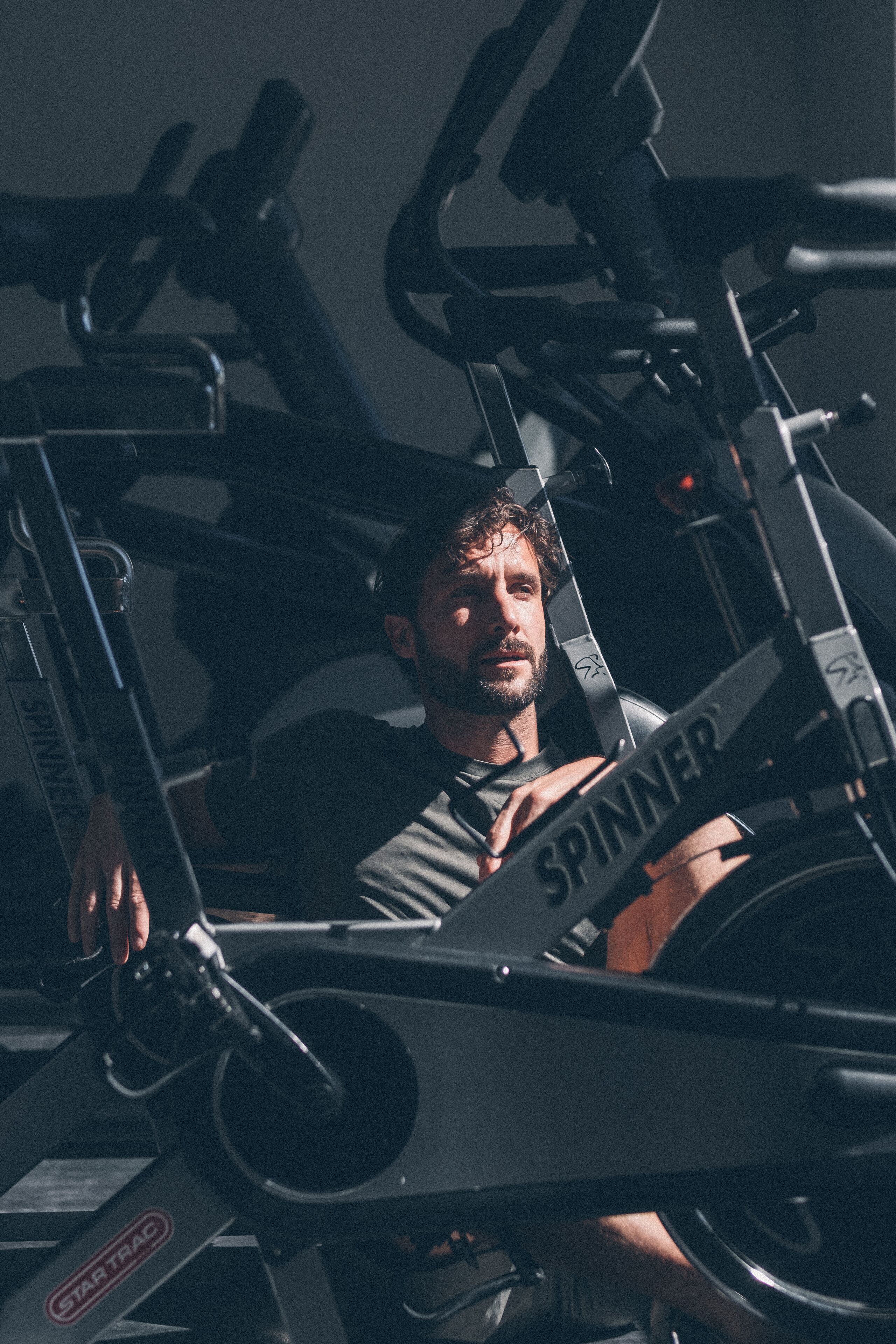 A stationary bike with the brand name "SPINNER" visible.