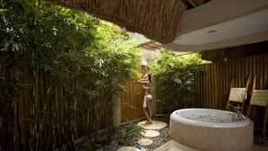 A spa area with a hot tub surrounded by bamboo plants and a wooden fence. - Eskaya Beach Resort and Spa (Panglao)