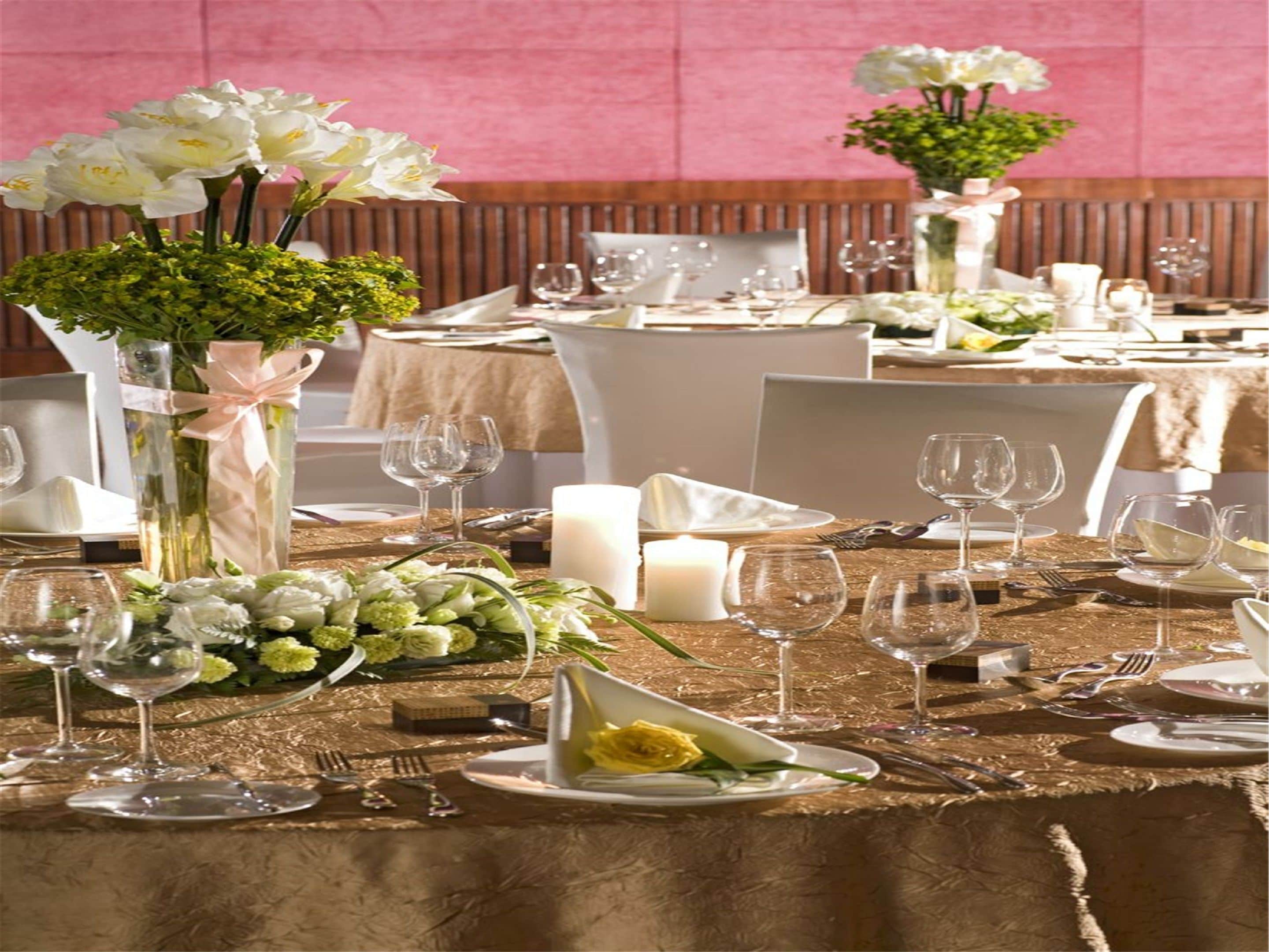 A dining area with tables set for a meal, featuring clear glassware, plates, and cutlery.