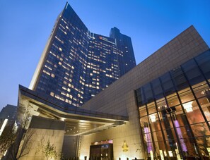 A modern building with a prominent glass facade and a large entrance area. - Grand Millennium Beijing (Beijing)