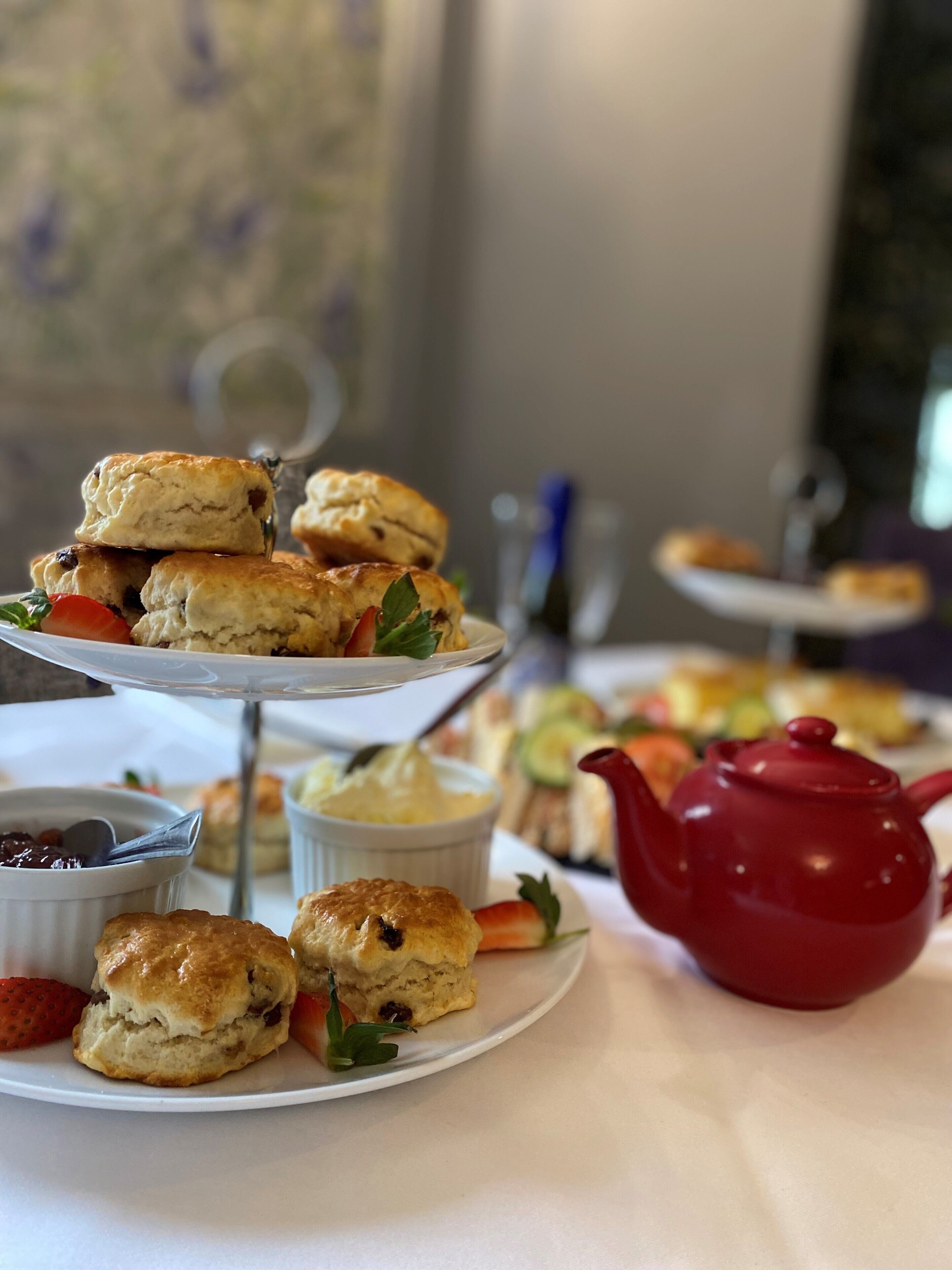 A table with various pastries and a teapot.