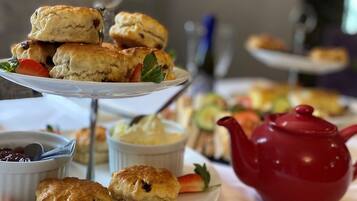 A table with various pastries and a teapot.