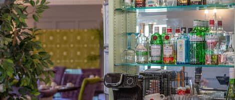 A bar area with shelves of liquor bottles and a coffee machine.