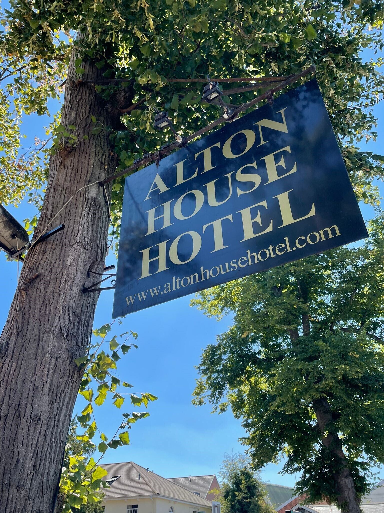 A sign for Alton House Hotel with a website address.