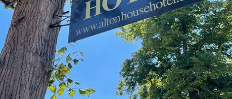 A sign for Alton House Hotel with a website address.