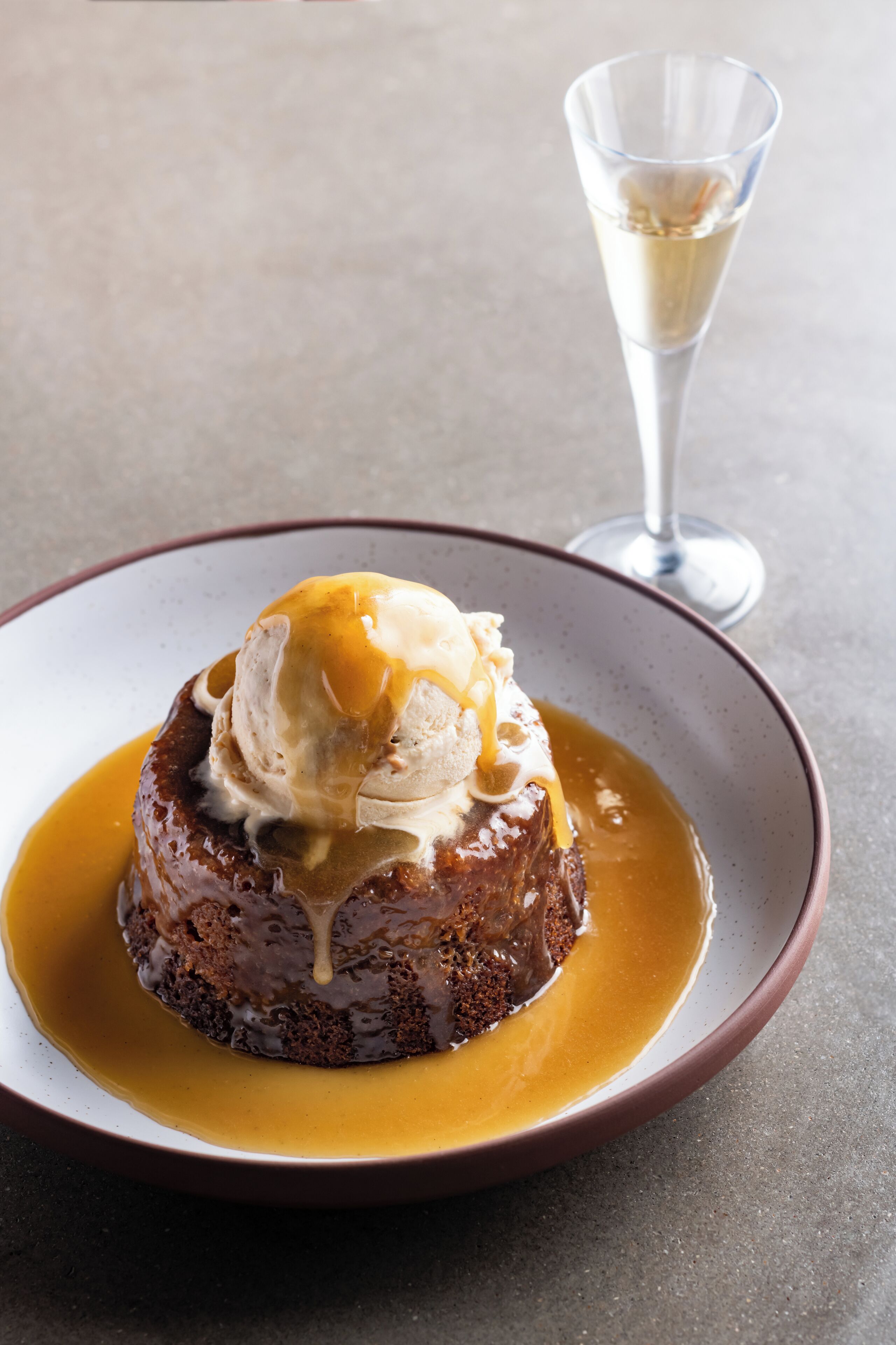 A dessert with caramel sauce and ice cream on a plate.