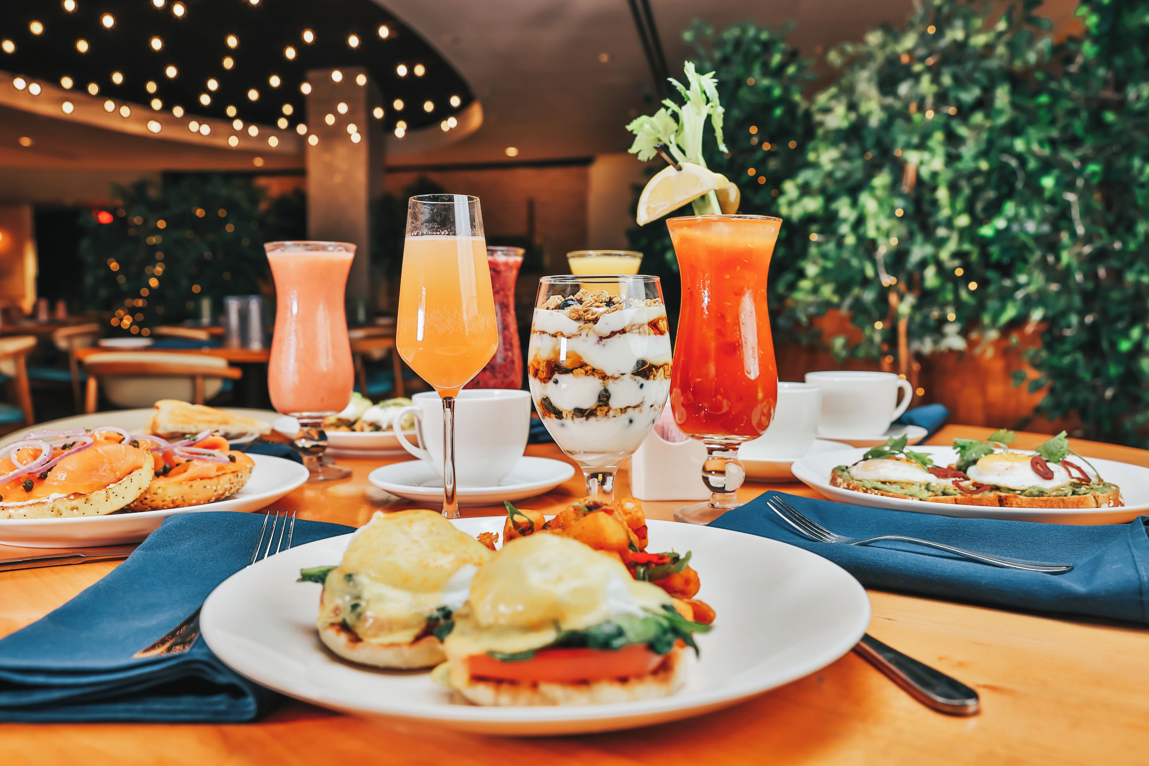 A restaurant setting with various dishes and drinks on the table.