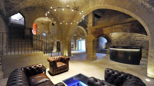 A lobby with stone arches, leather sofas, a reception desk, and a staircase. - Hotel Schloss Waldeck (Waldeck)