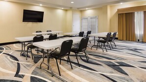 A conference room with a large table, chairs, a flat-screen TV, and a patterned carpet. - Best Western Comanche Inn (Comanche)