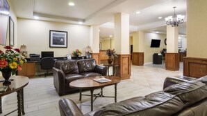 A spacious lobby with leather sofas, a reception desk, and a chandelier. - Best Western Comanche Inn (Comanche)
