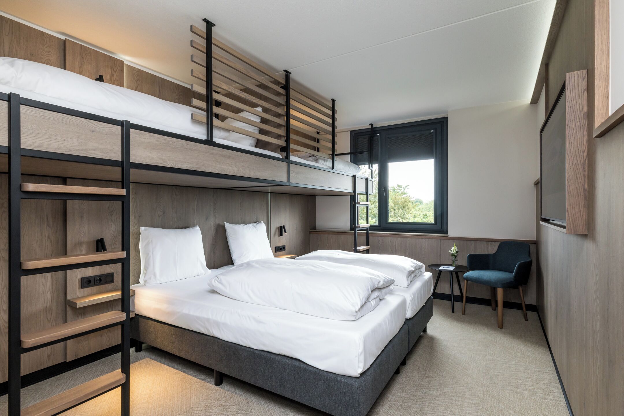 Habitación con literas, escritorio, silla y ventana.