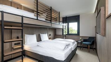 A bunk bed room with a desk, chair, and window.