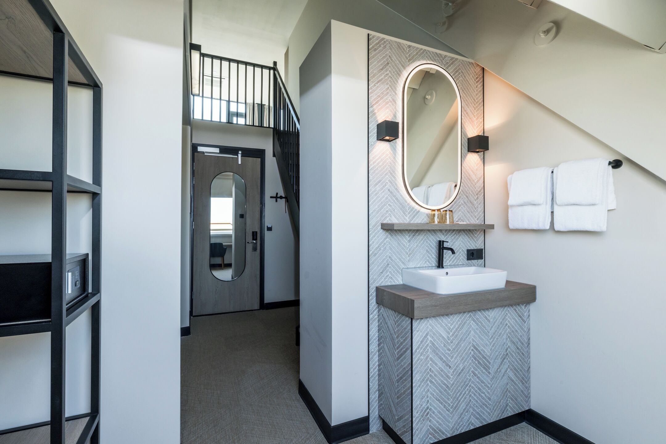 Une salle de bain moderne avec une baignoire sur pieds, un meuble-lavabo avec un miroir et un porte-serviettes.