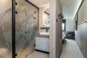 Habitación Deluxe | Baño | Ducha, artículos de higiene personal gratuitos y secador de pelo