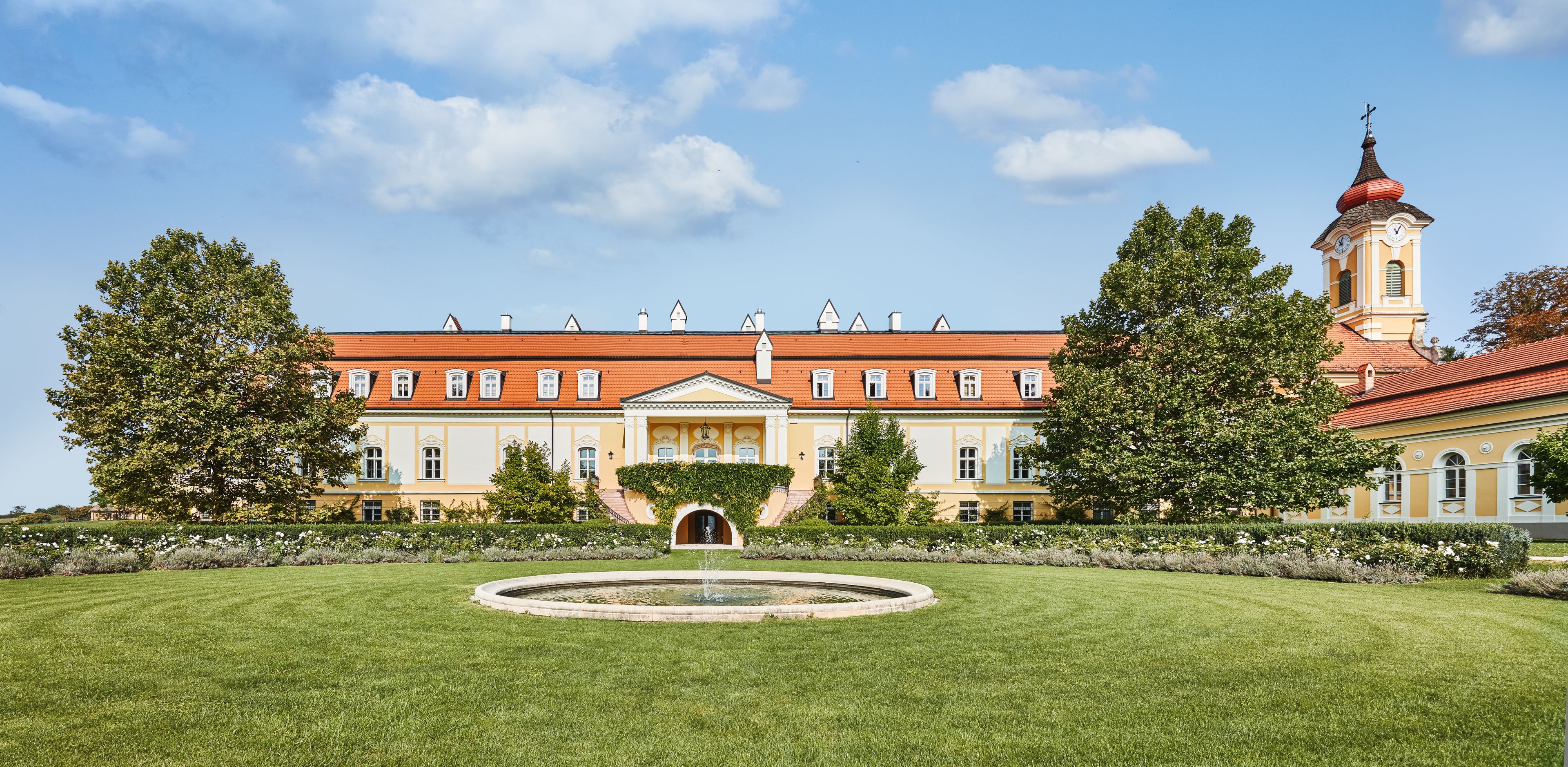 A large, historic building with a central courtyard and a fountain.