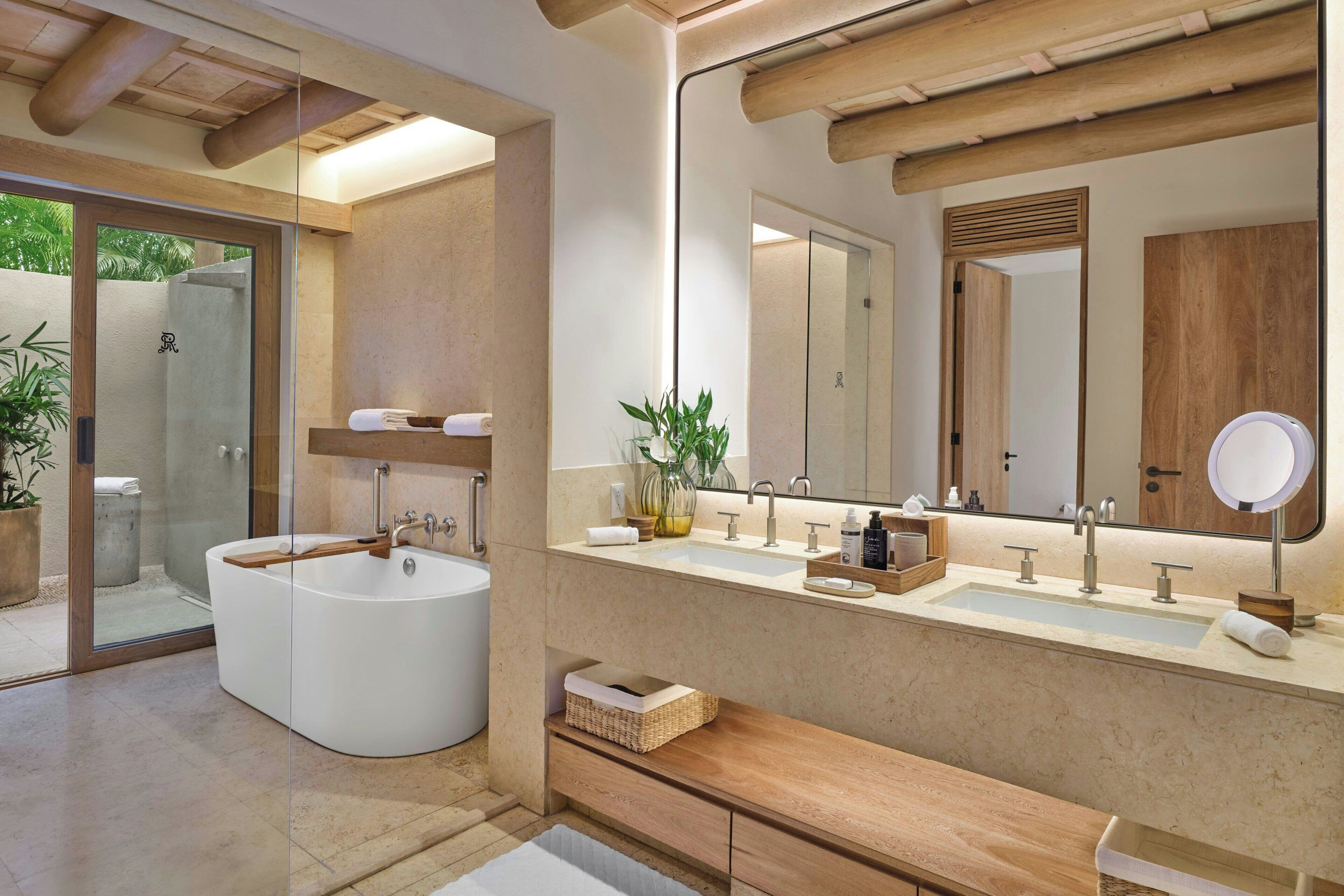 Une salle de bain moderne avec une baignoire sur pieds, un grand miroir et un meuble-lavabo en bois.