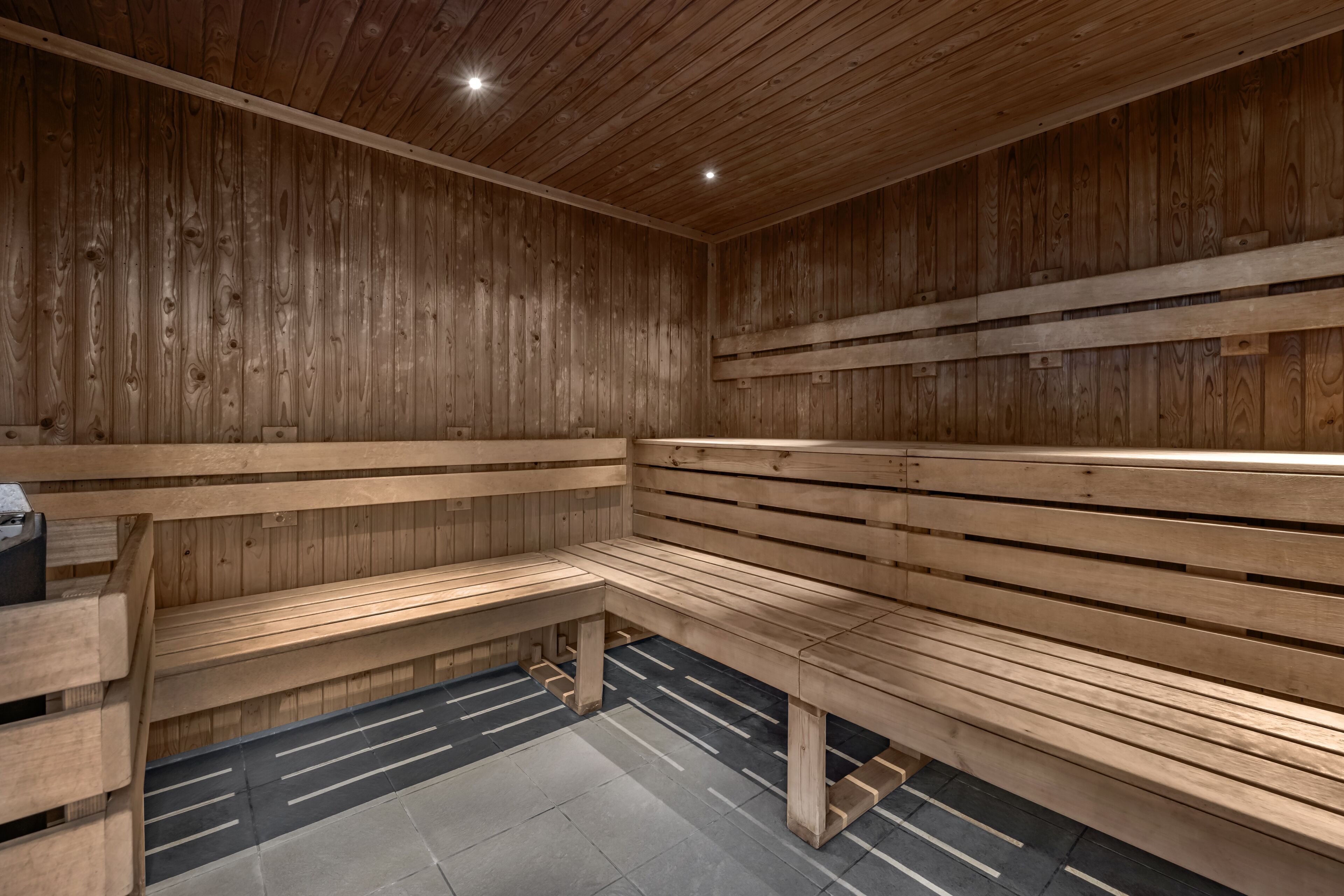 A sauna with wooden benches and a tiled floor.