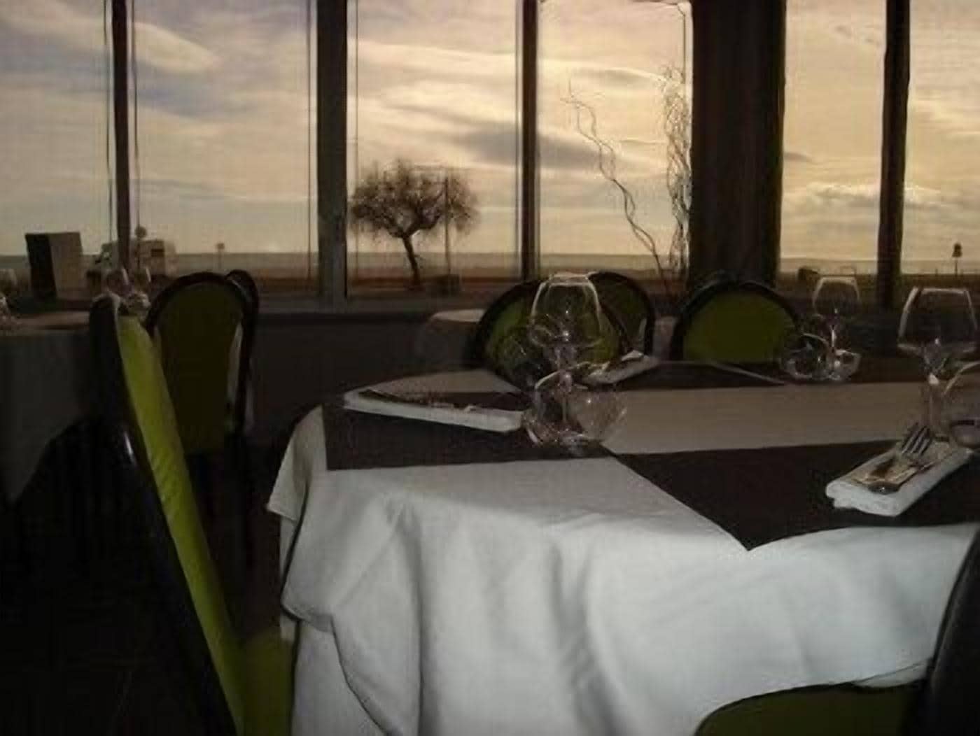 Une table à manger dressée pour quatre personnes, avec vue sur le paysage.