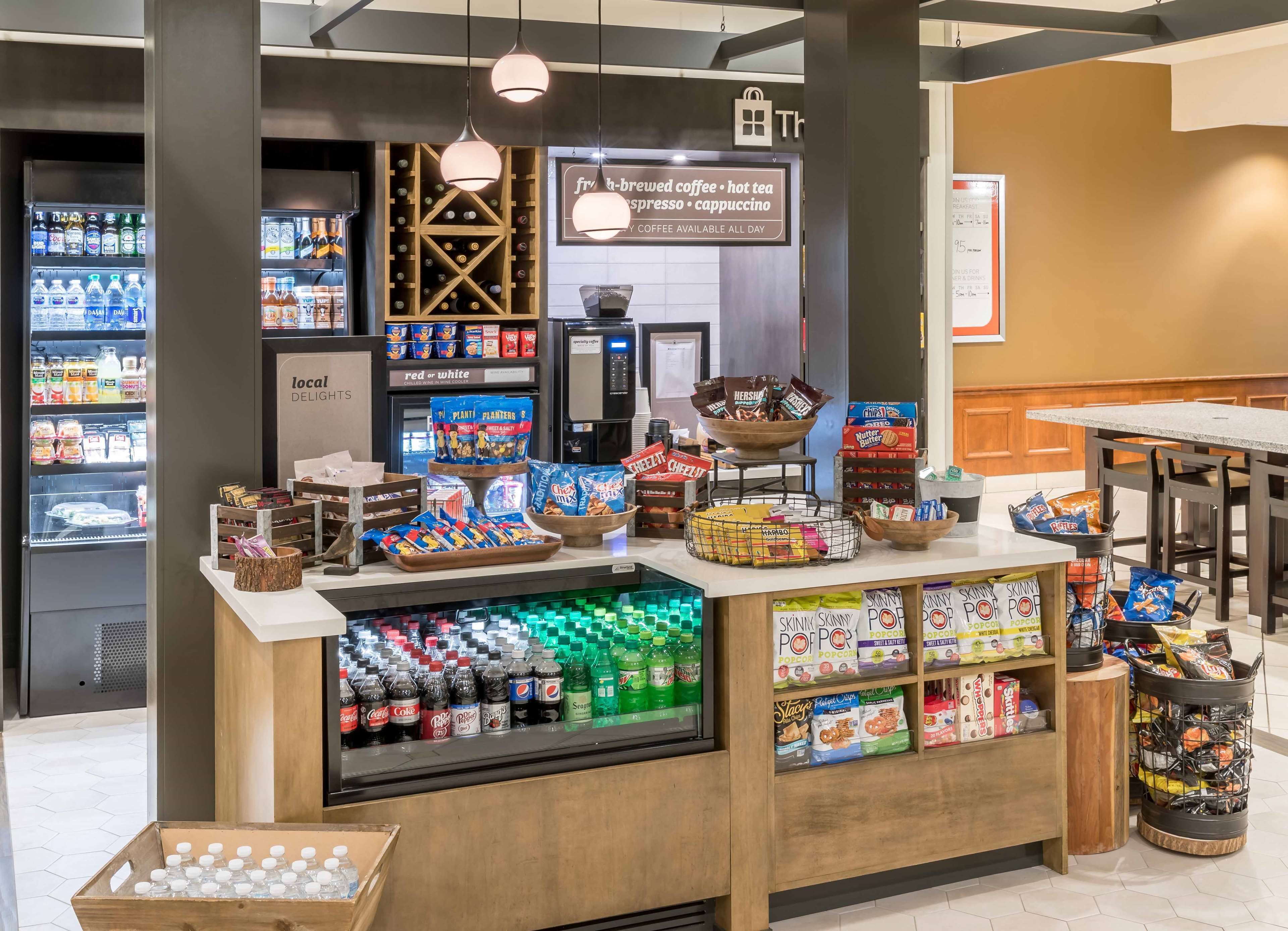 A snack and beverage kiosk with a variety of snacks, drinks, and a coffee machine.