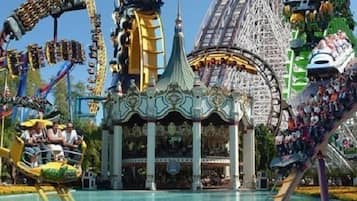 Un parque de atracciones grande con diversas atracciones y un edificio central con columnas.