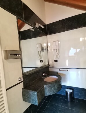 Un baño moderno con diseño de azulejos blanco y negro, un lavabo integrado y un inodoro.