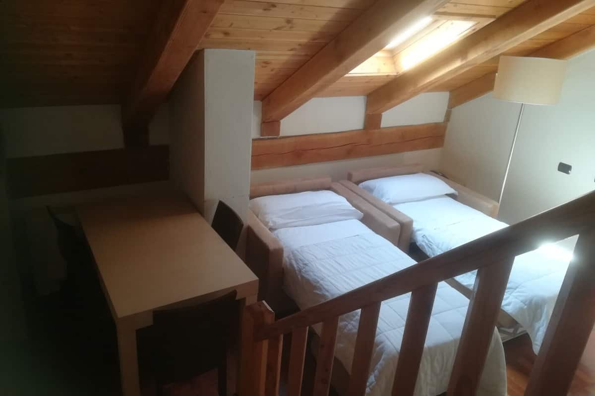 Une petite pièce agréable, dotée de deux lits, d’un bureau et d’une chaise.