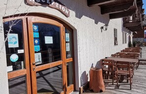 A reception area with a wooden door and windows displaying various signs and information.