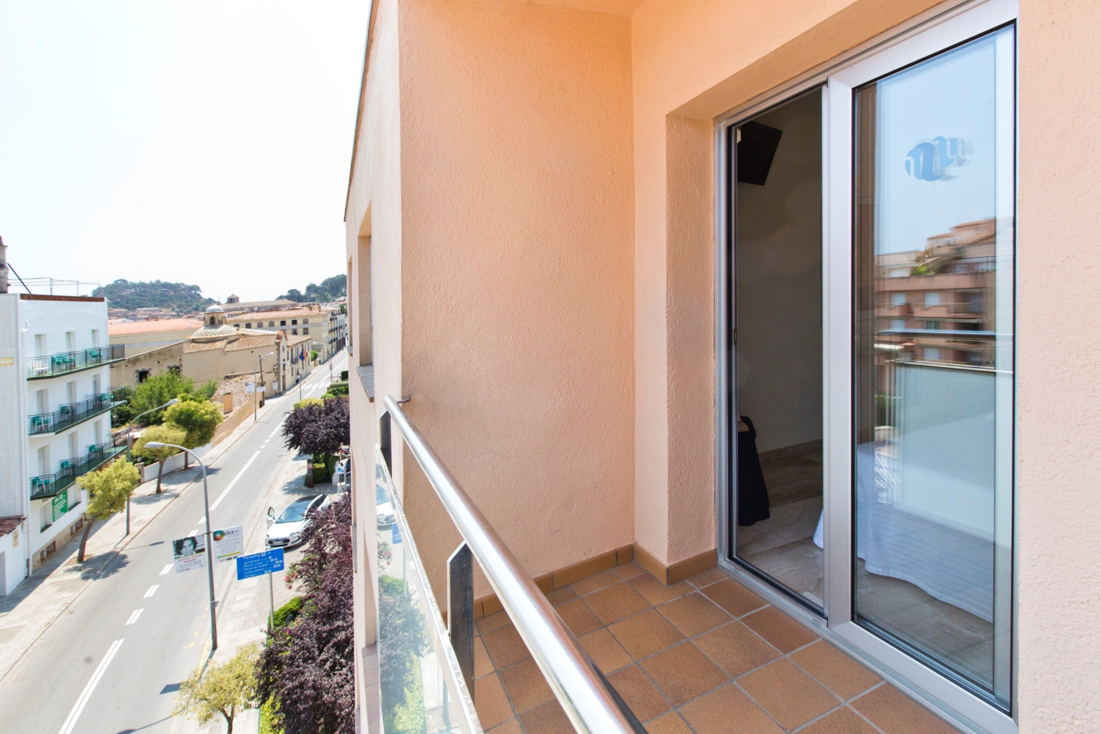 A balcony with a view of a street and buildings.