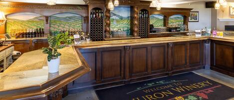 A bar area with a wine rack, a welcome mat, and a potted plant.
