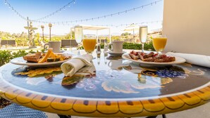 A table set for breakfast with plates of food, glasses of orange juice, and a pitcher of water.