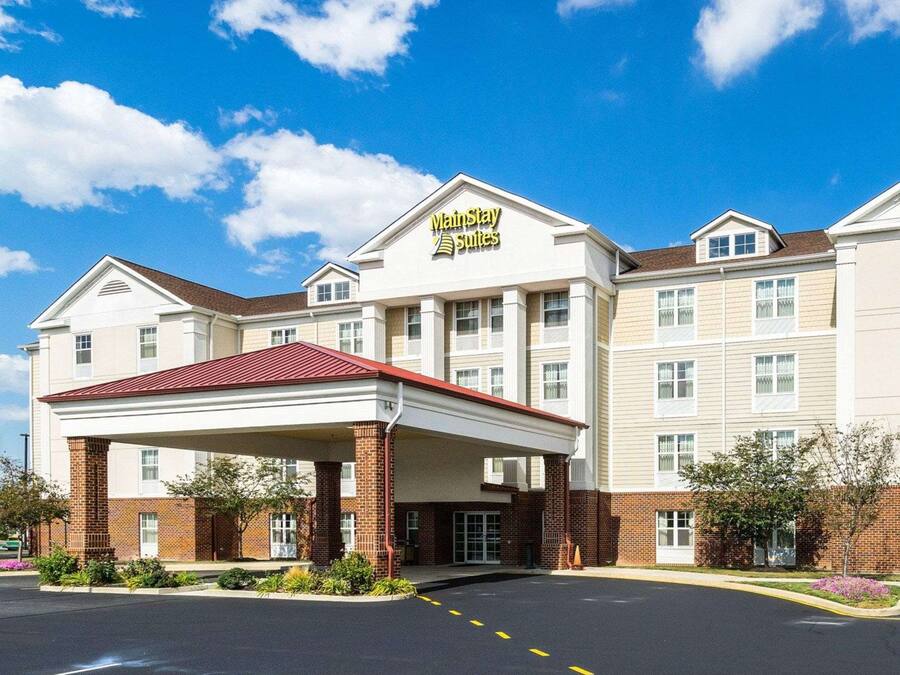 Un hôtel Marriott Suites doté d’une entrée couverte, d’une façade en briques et de nombreuses fenêtres.