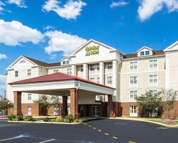 Un hotel Marriott Suites con entrada cubierta, fachada de ladrillo y varias ventanas.