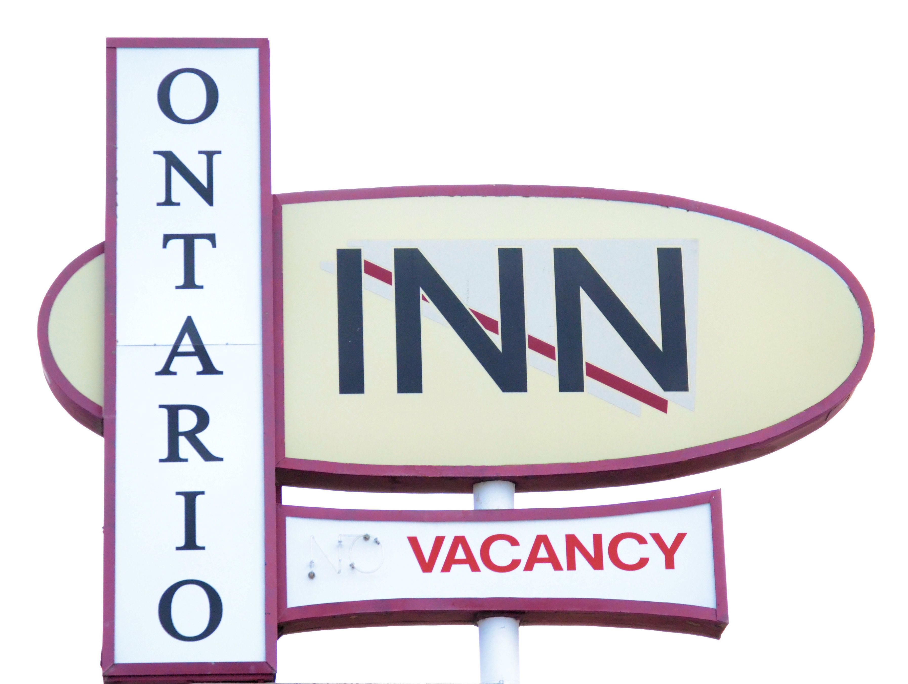 Un cartel con 'ONTARIO' e 'INN' que indica una ubicación, y un letrero de 'VACANCIA' debajo.