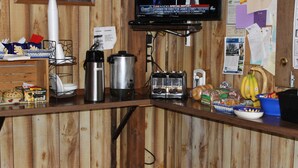 A wooden counter with a coffee maker, toaster, and various food items. - Ontario Inn (Ontario)