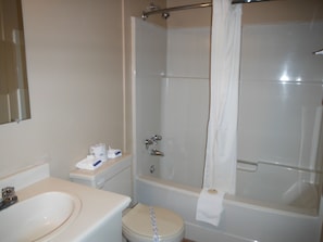 A bathroom with a toilet, sink, and shower.